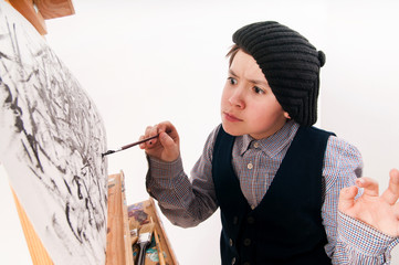 artist school boy painting brush watercolors portrait on a easel