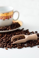 Coffee grains, wooden spoon and white cup