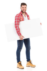 Smiling man in lumberjack shirt holding blank placard