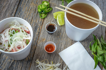 Pho Fast Food To Go on Wood Background with Peppers and Basil