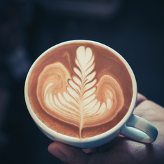 cup of coffee latte art on the wood background in vintage color