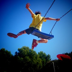 Niño saltando del columpio