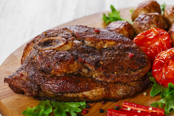 roasted pork shoulder on the bone with potatoes