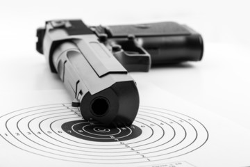 Paper target and pistol on white
