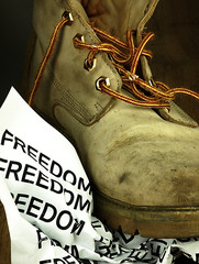 The word freedom crushed by a heavy, old military boot.