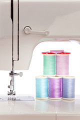 Weiße Nähmaschine und bunte Zwirne