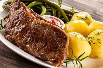Beefsteaks, boiled potatoes and vegetables