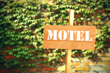 Signboard with text Motel on brick wall background
