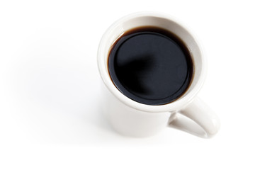 White cup full of black coffee stands on the table
