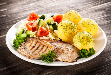 Grilled steaks, boiled potatoes and vegetable salad