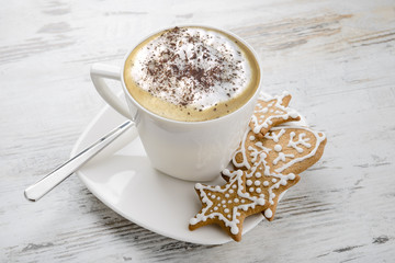 Cup of cappuccino and Christmas  gingerbread on table.