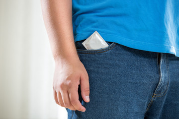 young man in jeans with condom in pocket