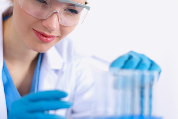 Fototapeta premium Woman researcher is surrounded by medical vials and flasks