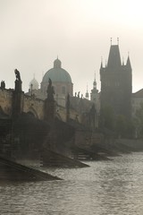 Morning autumn foggy Prague gothic Charles Bridge with Old Town