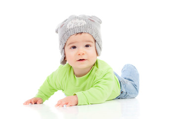 Beautiful baby  with wool hat lying on the floor