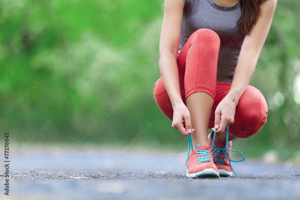 Wall mural Running shoes - closeup of woman tying shoe laces