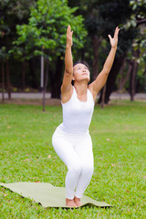 Beautiful woman practicing yoga in the park