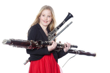 Fototapeta premium young girl holds woodwind instruments in studio