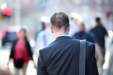 Suit in silhouette, sidewalk crowd