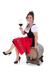 Frau im Dirndl auf Fass sitzend mit Rotwein Porträt