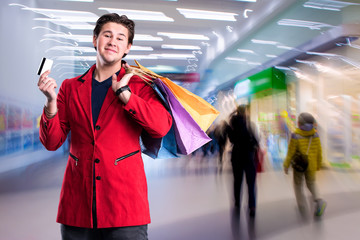 Smiling handsome man with shopping bags and credit card