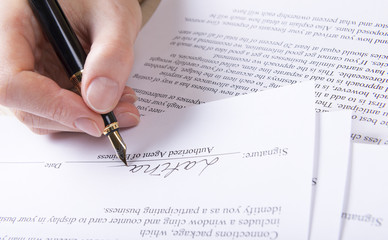 hand puts the signature in the contract