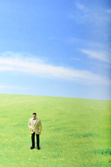 Obraz premium 草原に佇むタキシードの男性