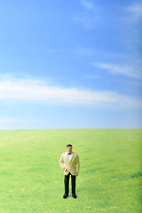 草原に佇むタキシードの男性