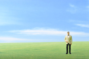 草原に佇むタキシードの男性