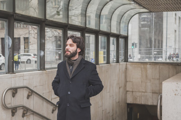 Young handsome bearded man posing in the city streets