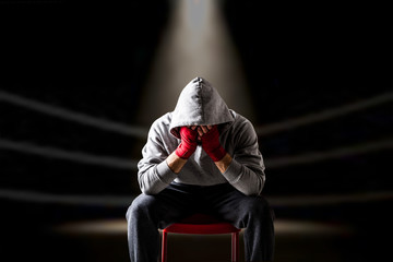 Defeated boxer seating on the ring - obrazy, fototapety, plakaty