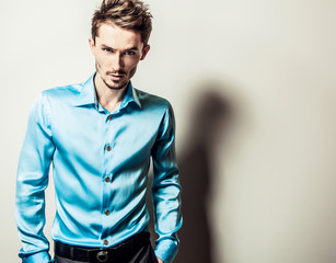 Elegant young handsome man in blue silk shirt. 