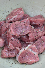 Raw pieces of pork sirloin seasoned and ready to cook.