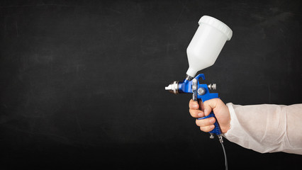 Painter works with airbrush gun and empty copyspace