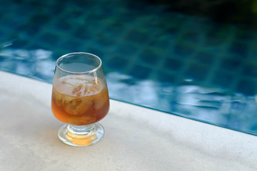 glass of ice tea beside the pool