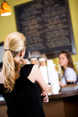 Coffee: Anonymous Woman Reading Menu Board