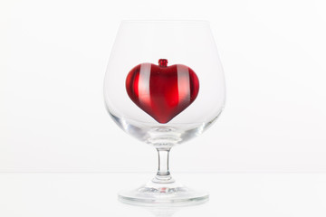 Red heart inside a glass of cognac