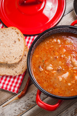 Knuckle soup with beans in pot. Vertical edit, top view.