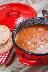 Knuckle soup with beans in pot. Vertical edit.