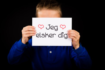 Child holding sign with Danish words Jeg Elsker Dig - I Love You