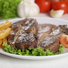 Steaks vom Schwein Fleisch mit Pommes und Salat auf Teller
