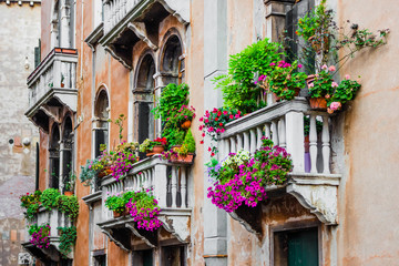 Fototapeta na wymiar Balconies of residential house in Venice decorated with flowers