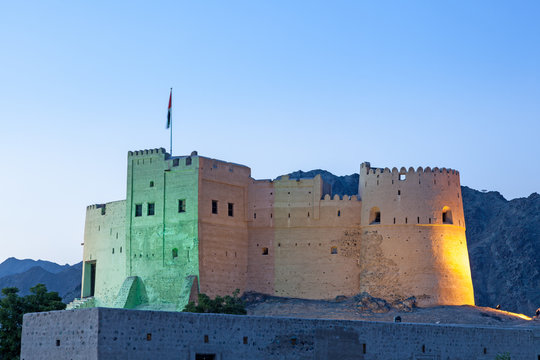Historic fort in Fujairah illuminated at dusk, UAE
