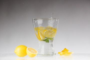 Splashes of water, lemon falling into a glass