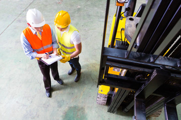 forklift truck driver and foreman in storage