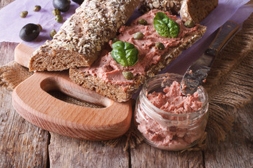 Sandwich with goose pate, capers and basil close-up