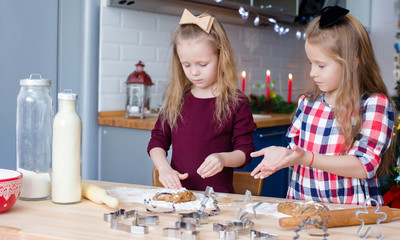 Little girls baking gingerbread cookies for Christmas at home