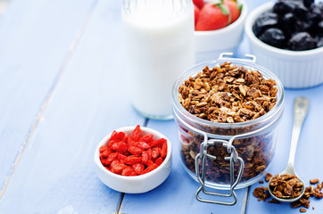 granola with milk, nuts, goji berries and strawberries.
