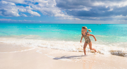 Fototapeta na wymiar Adorable little girl on white beach during tropical vacation