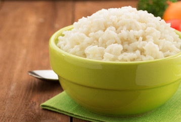 bowl full of rice isolated on wood